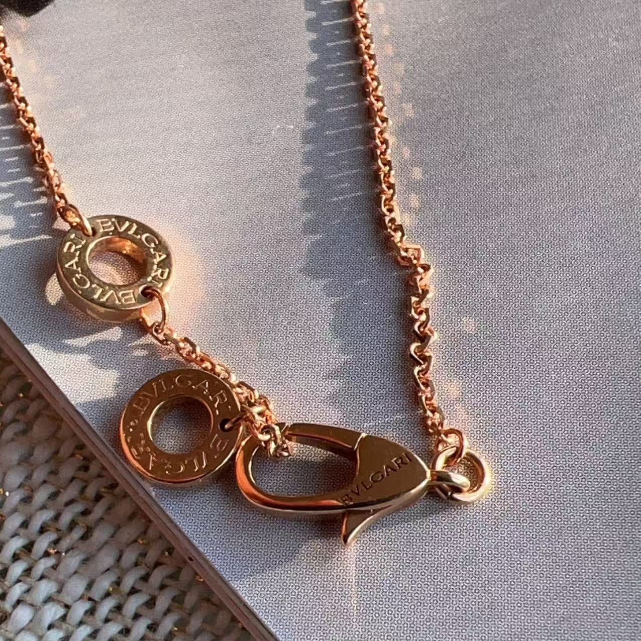 Rose gold necklace with a clasp on a textured surface