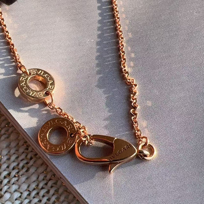 Rose gold necklace with a clasp on a textured surface