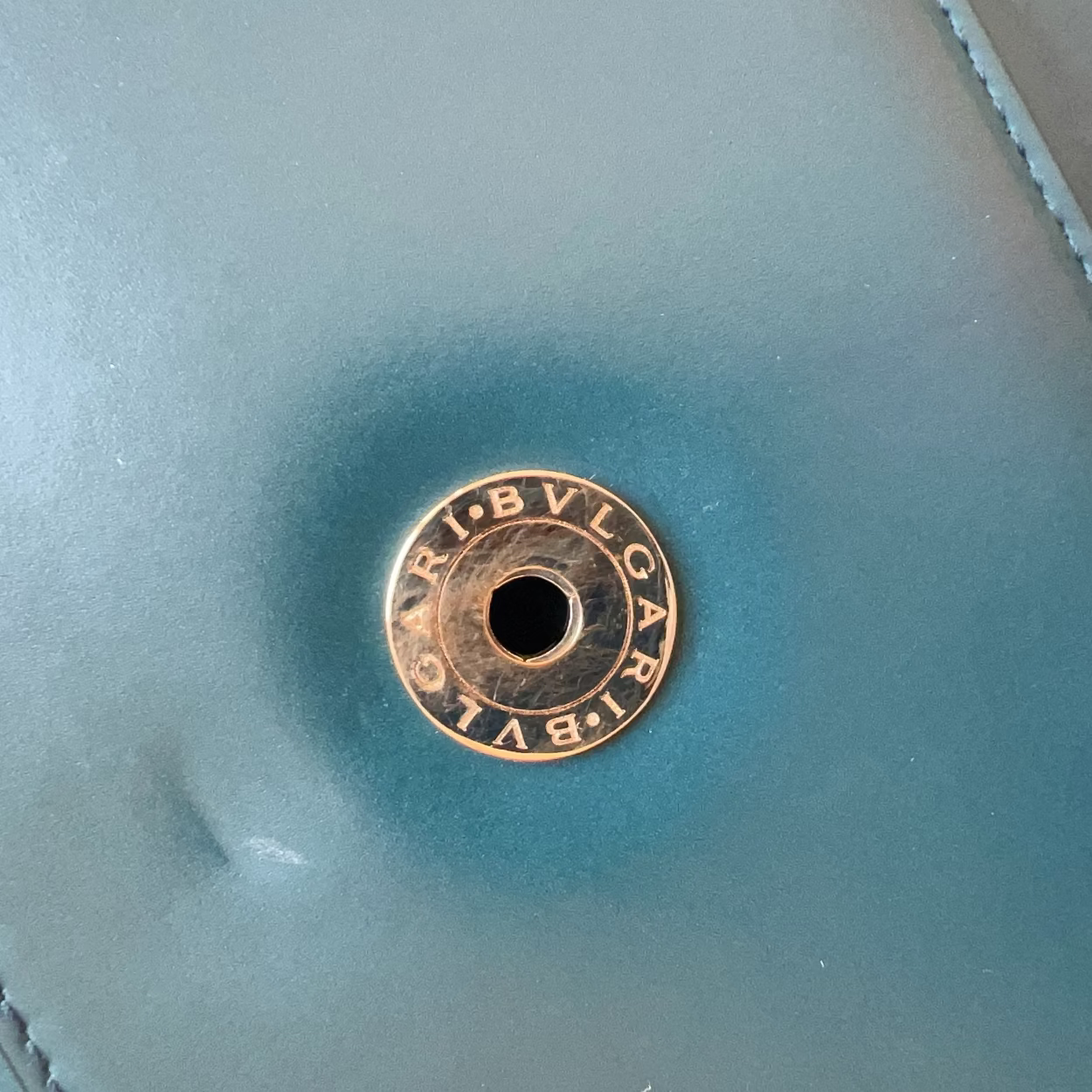 Bulgari logo on a light blue leather surface