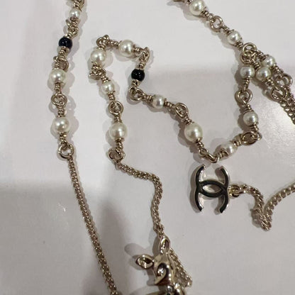Chanel necklace with pearl and chain details on a white background