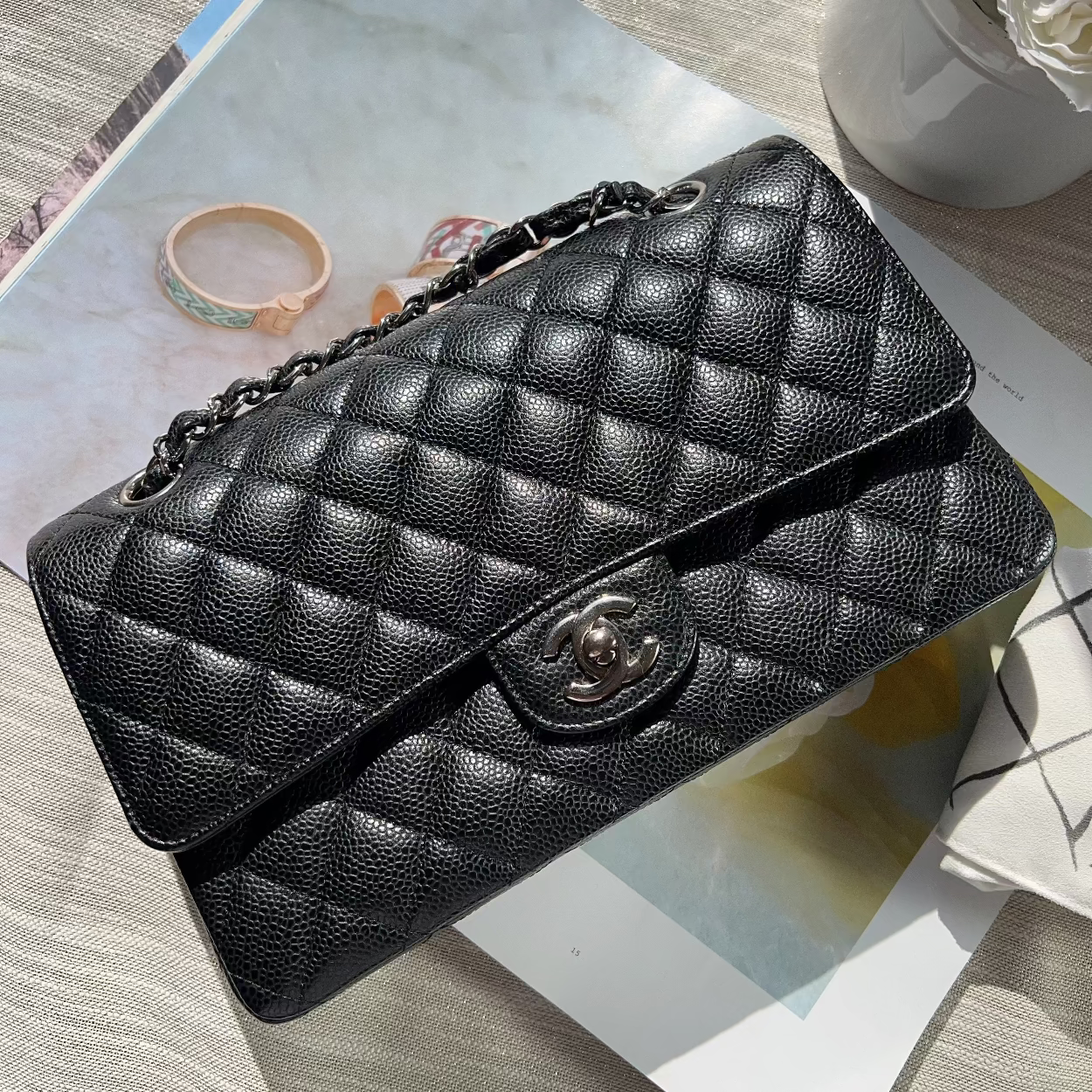 Black quilted handbag on a magazine with a light background