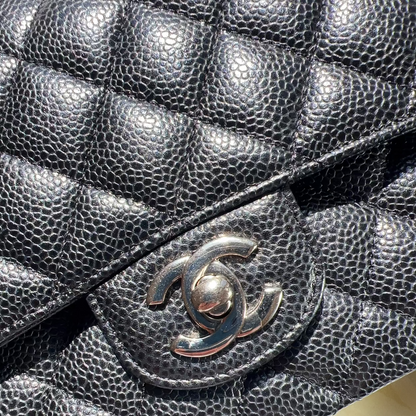 Close-up of a black quilted handbag with Chanel logo.