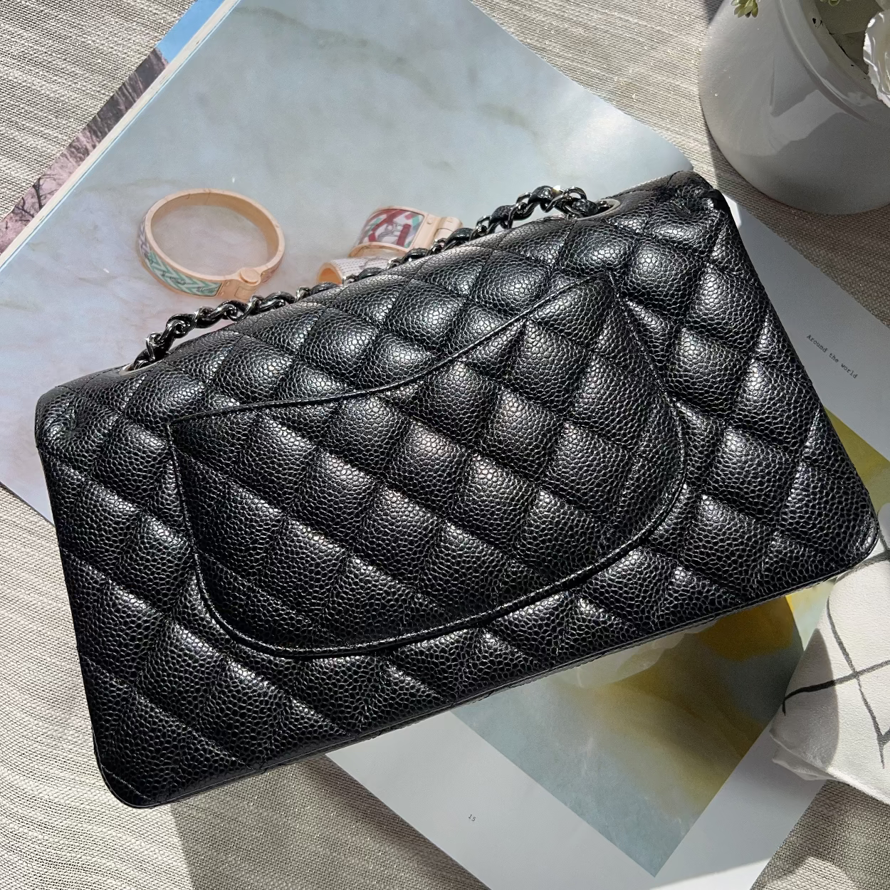 Black quilted handbag on a magazine with a light background