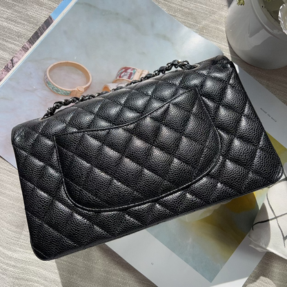 Black quilted handbag on a magazine with a light background