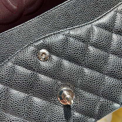 Close-up of a textured black handbag with a gold clasp.