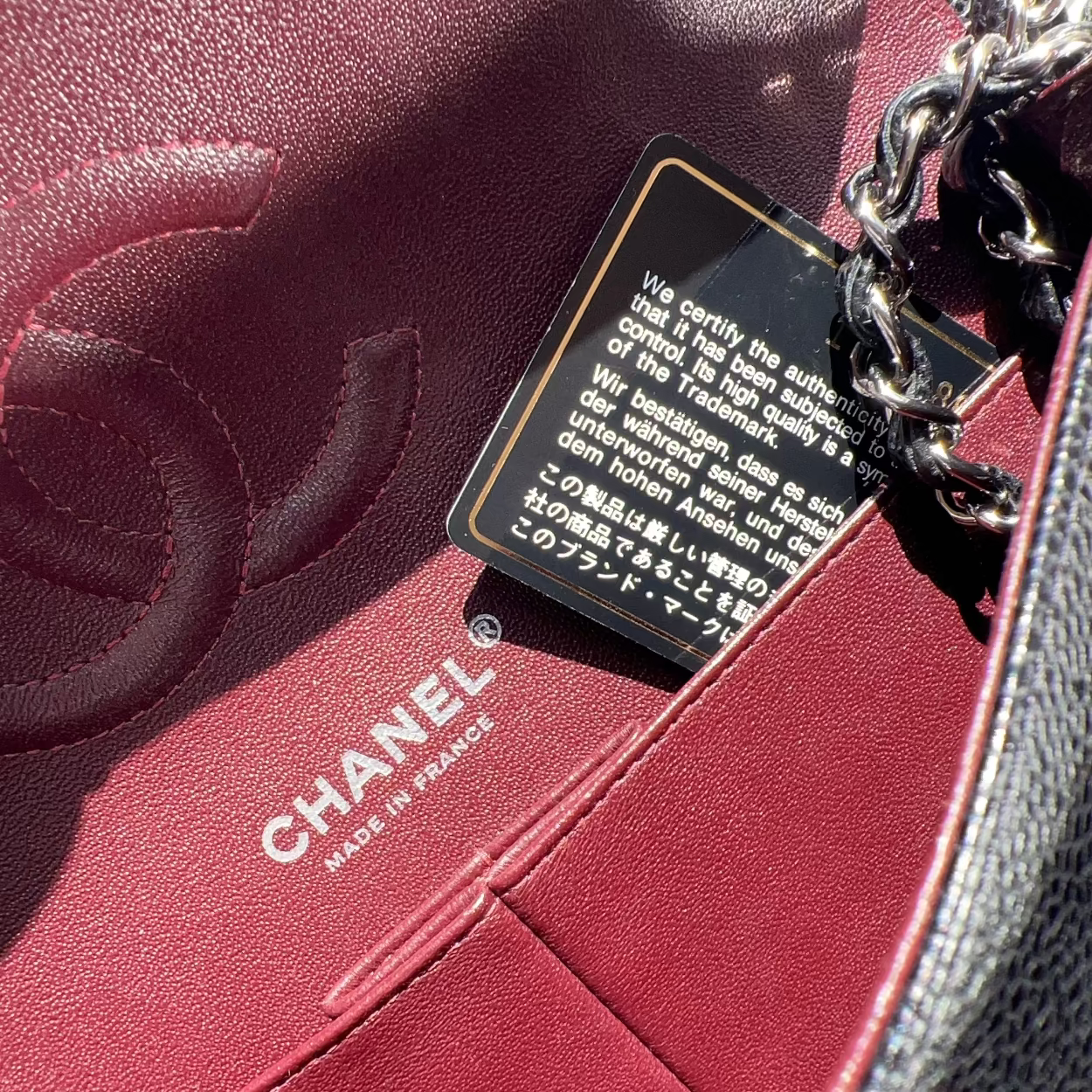 Close-up of a Chanel handbag with a brand label and authenticity card.