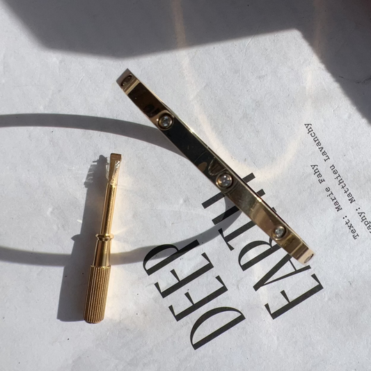 Gold hair clip and tool on a white surface with 'DEEP' text.