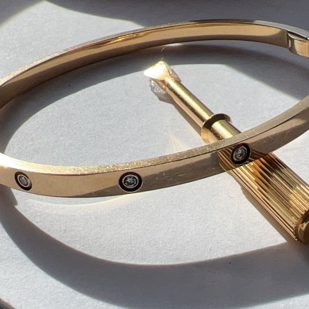 Gold bracelet with a unique design on a light gray background