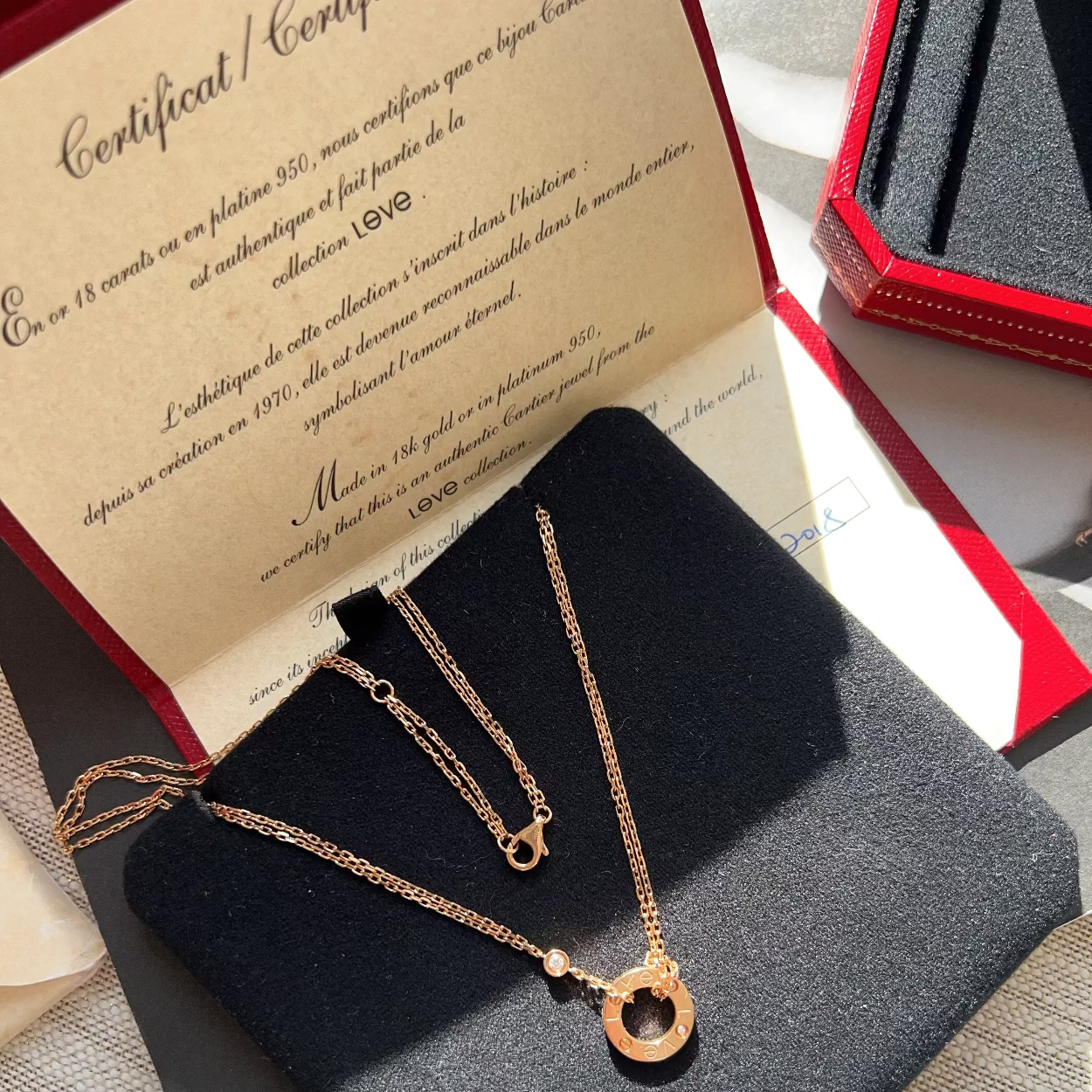 Gold necklace on a black stand with a certificate of authenticity in the background