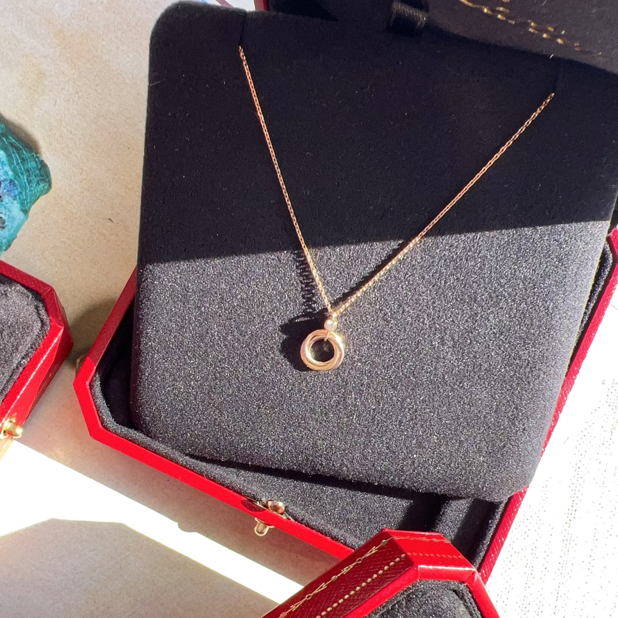 Gold necklace in a red jewelry box on a light background