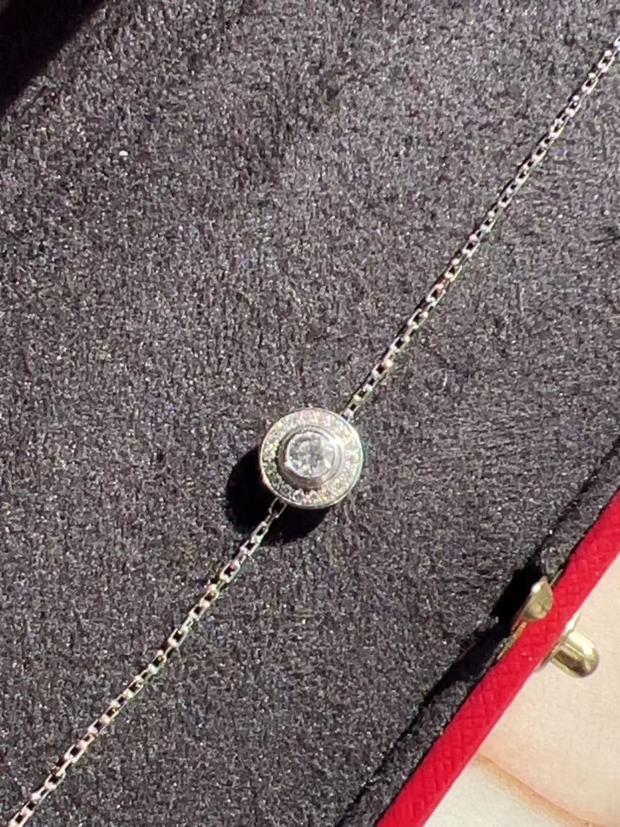 Silver necklace with a round pendant on a textured surface