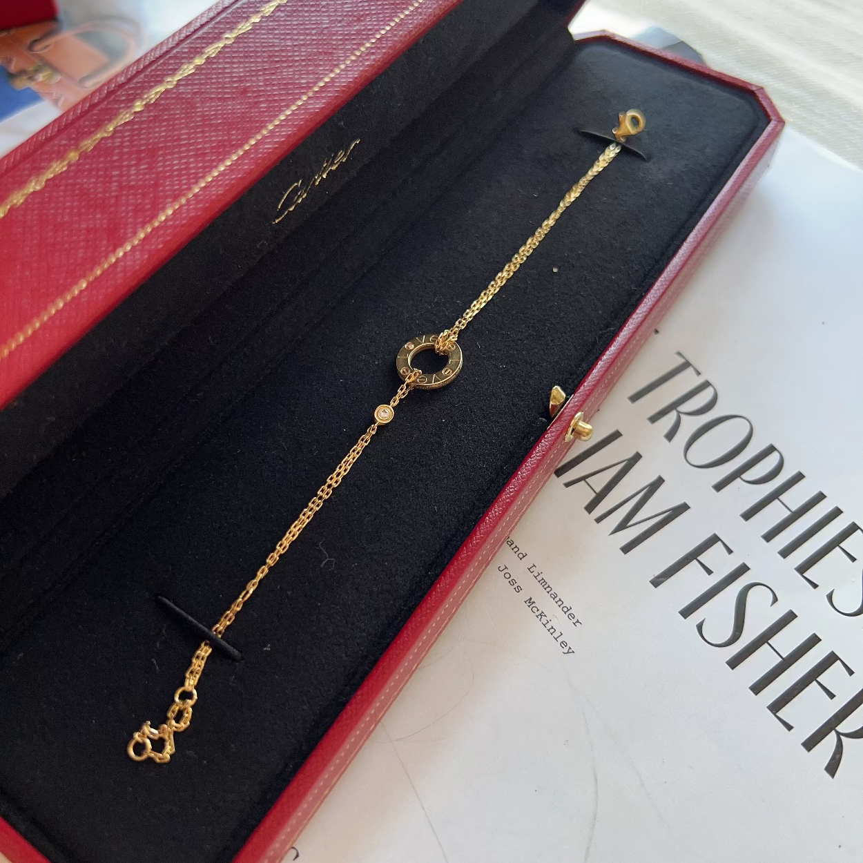 Gold necklace in a Gucci box on top of a book
