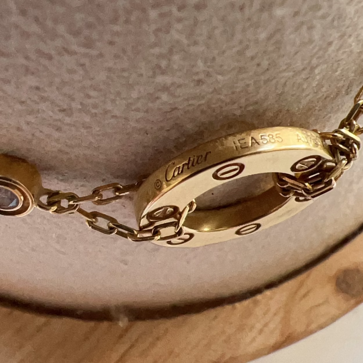 Close-up of a gold Cartier bracelet on a textured surface