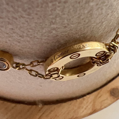 Close-up of a gold Cartier bracelet on a textured surface