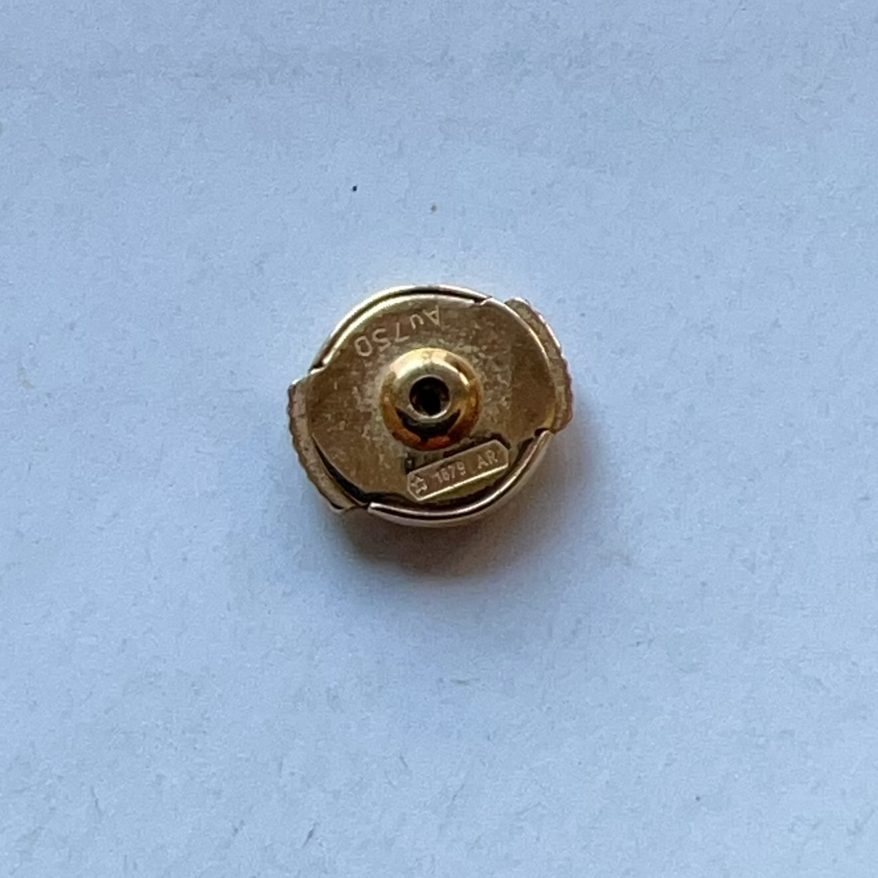Gold-colored metal cap on a light blue background