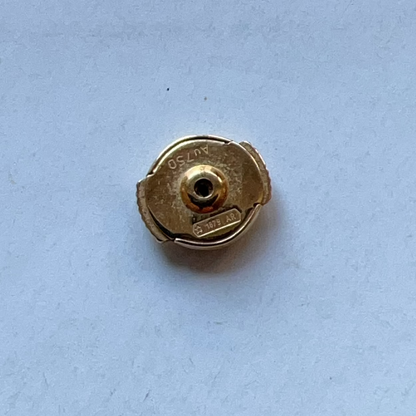 Gold-colored metal cap on a light blue background