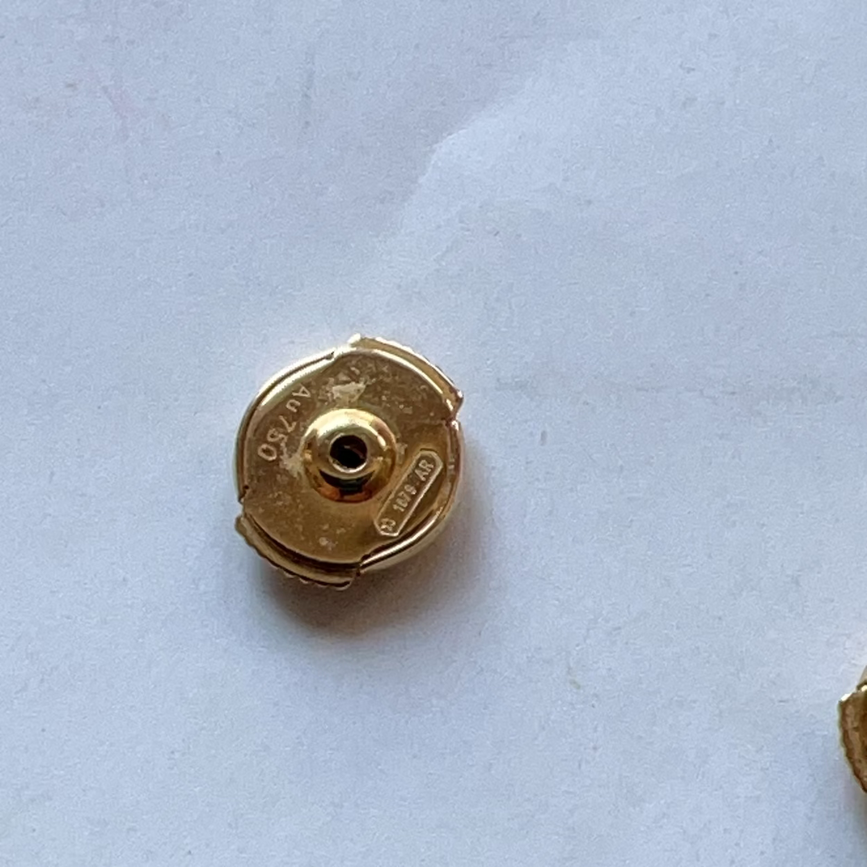 Gold-colored metal component on a light blue background