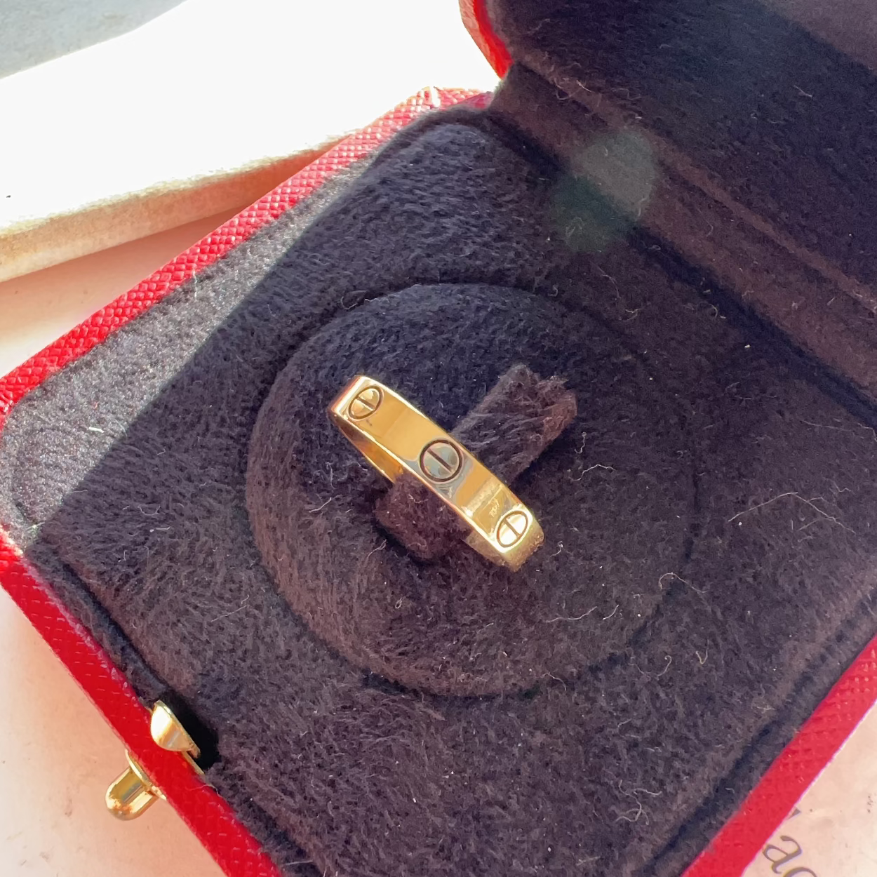Gold ring with symbols in a red jewelry box