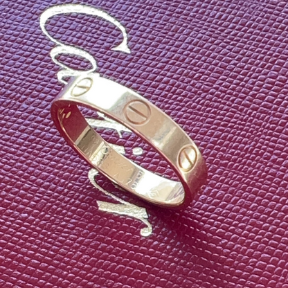 Silver ring with engraved symbols on a purple textured surface