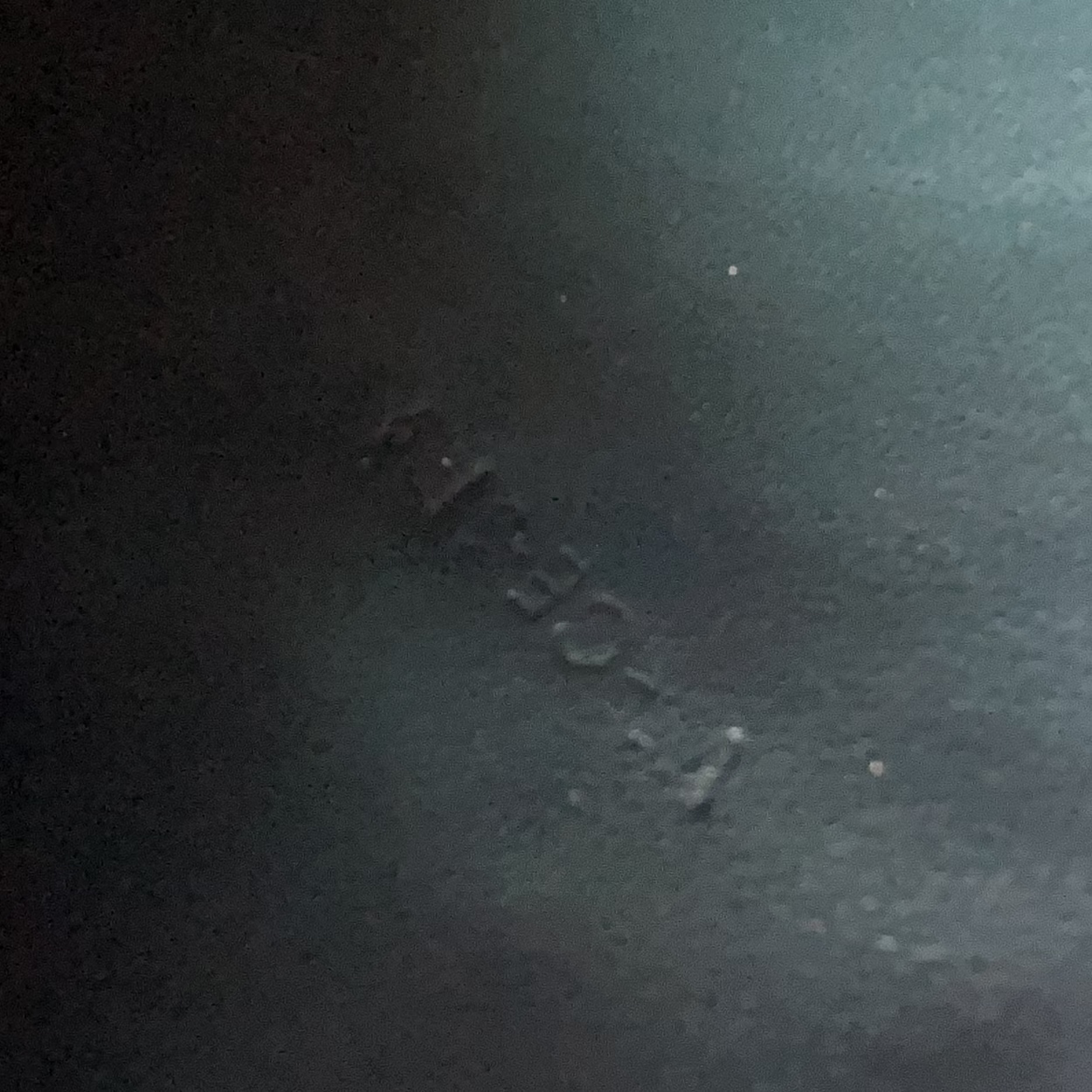 Dark textured surface with a visible brand logo.