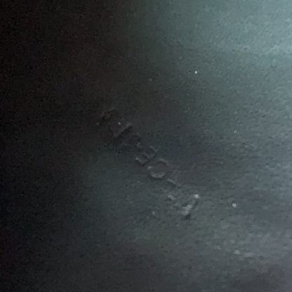Dark textured surface with a visible brand logo.