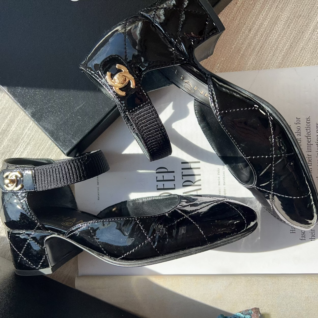 Black patent leather shoes with gold buckles on a magazine