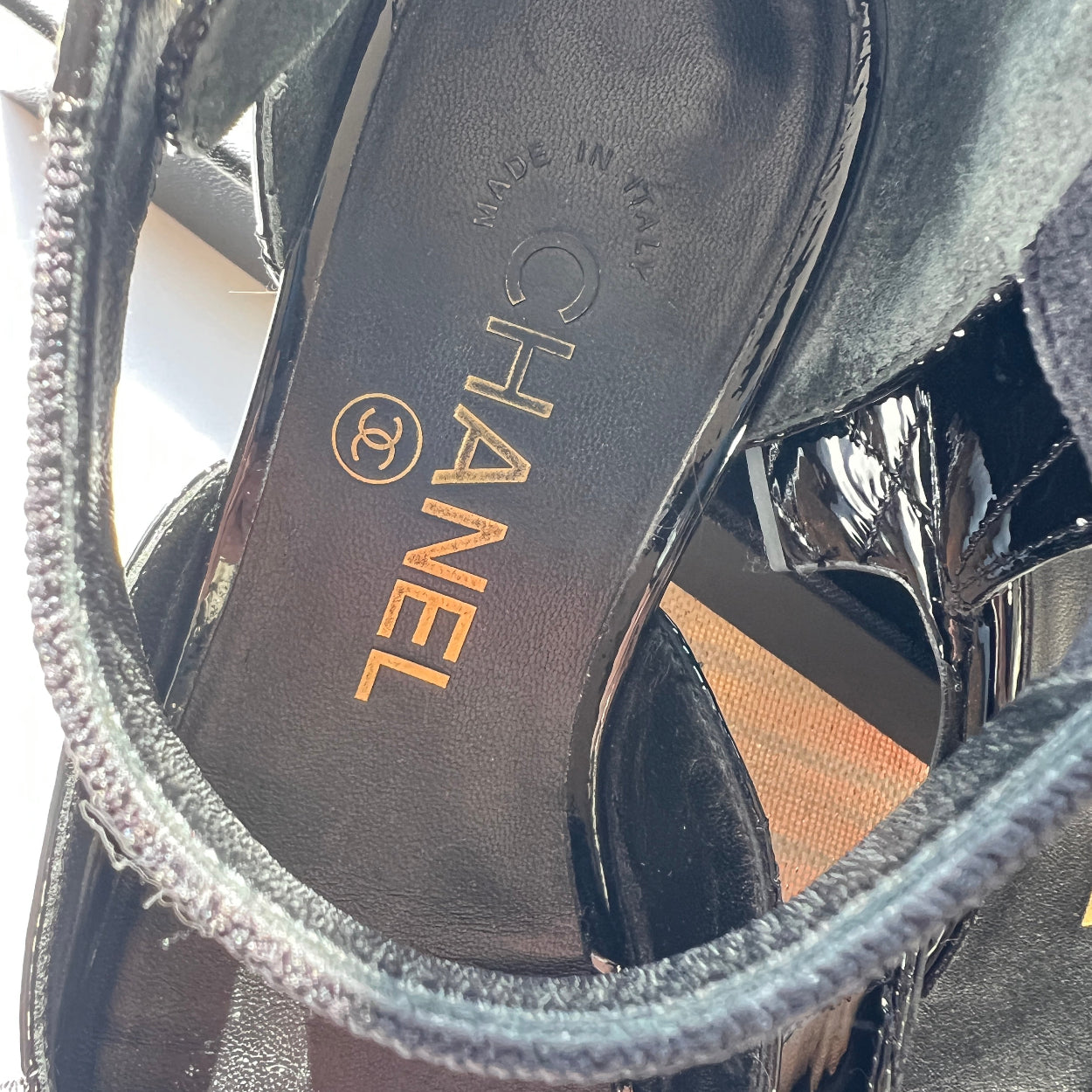 Close-up of Chanel sandals with a focus on the brand logo.