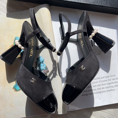 Black high-heeled sandals with pearl embellishments on a magazine page