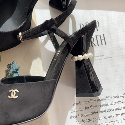 Black high-heeled shoes with pearl embellishments on a magazine page.