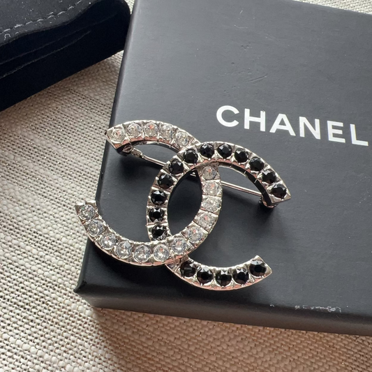 Chanel brooch on a Chanel box with a textured surface background