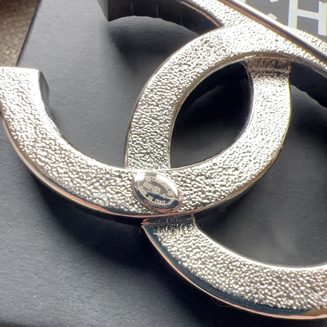 Silver textured belt buckle on a black background