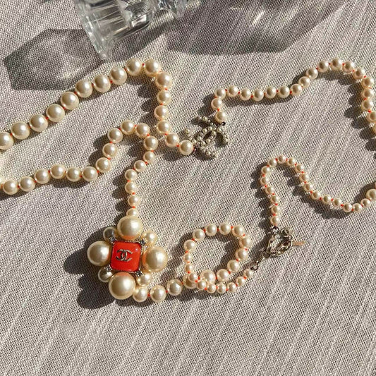 Pearl necklace with a red clasp 