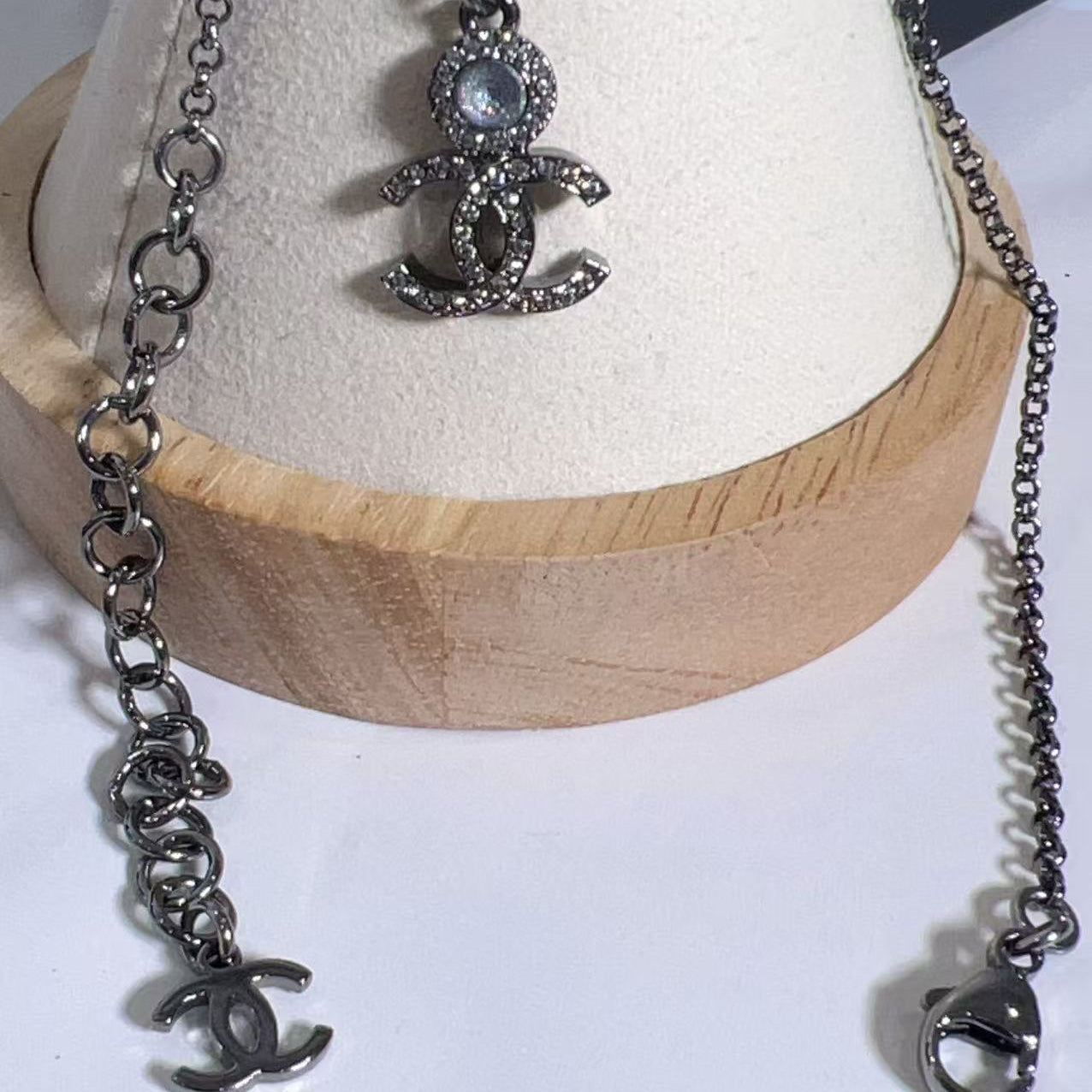 Silver necklace with pendant on a wooden stand