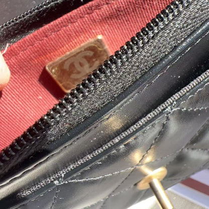 Close-up of a Chanel wallet with a red interior and gold logo.