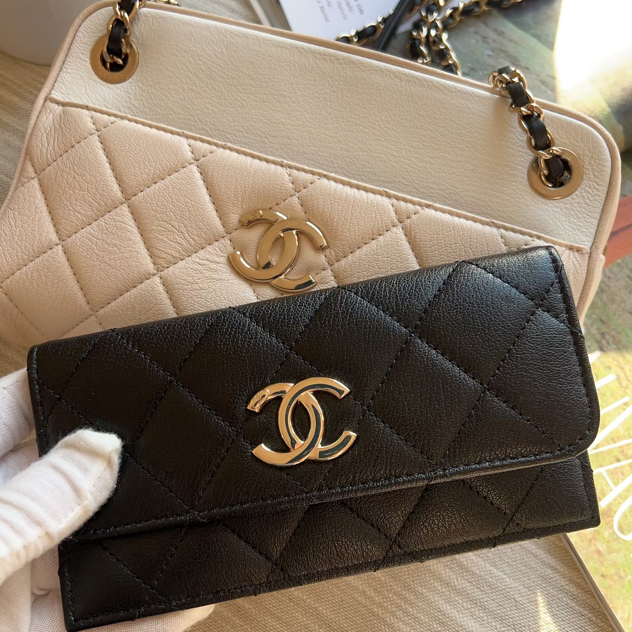 Black and beige quilted handbags with gold CC logo on a textured surface