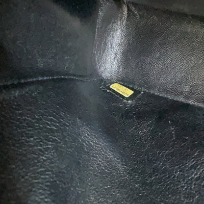 Close-up of a black leather surface with a visible brand label.