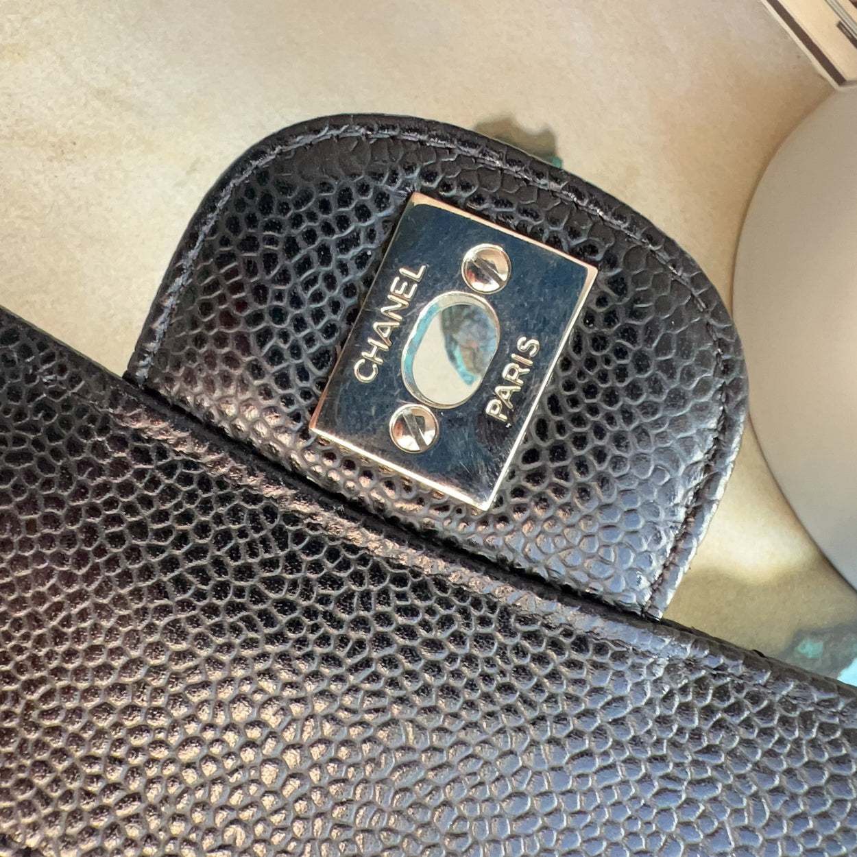 Close-up of a Chanel wallet with a textured surface and brand logo.