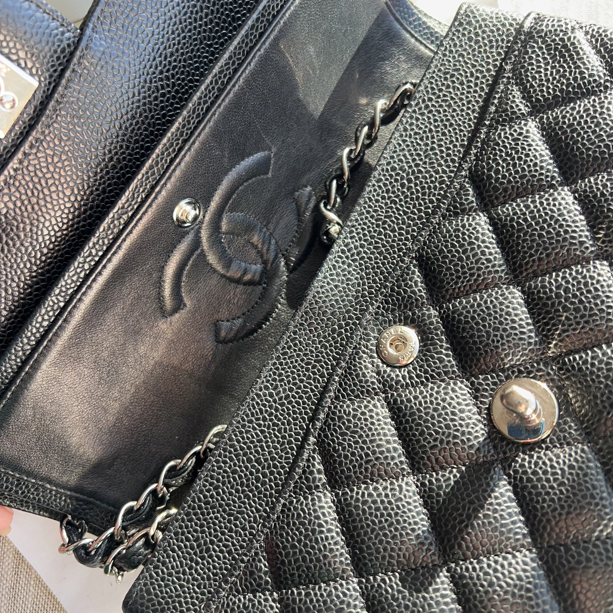 Black quilted handbag with Chanel logo on a light background