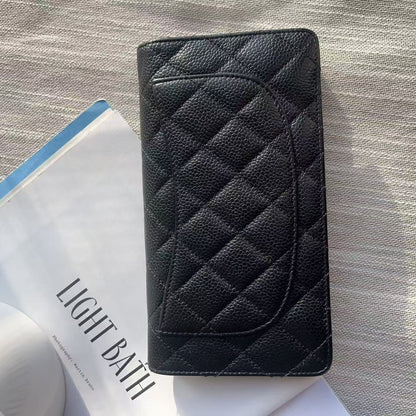 Black quilted wallet on a textured surface with a magazine underneath
