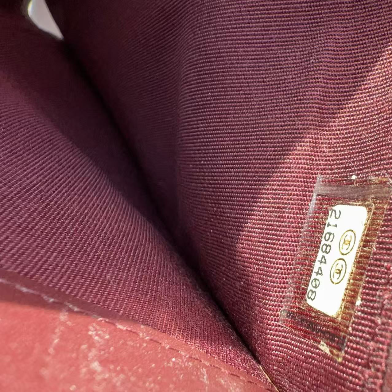 Close-up of a maroon fabric with a visible brand label.