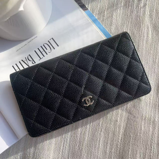 Black quilted wallet with Chanel logo on a textured surface