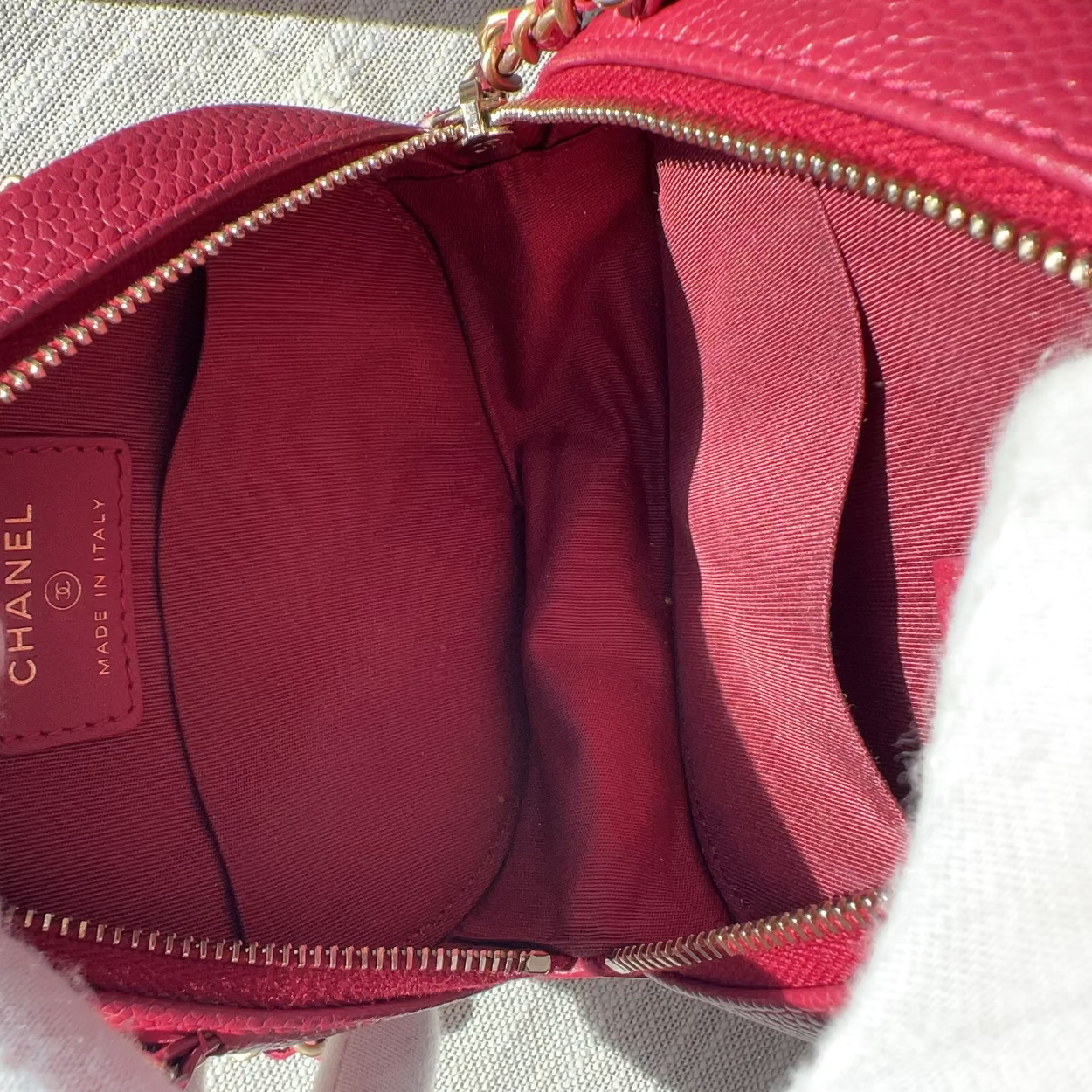 Red Chanel handbag with gold chain strap on a light background