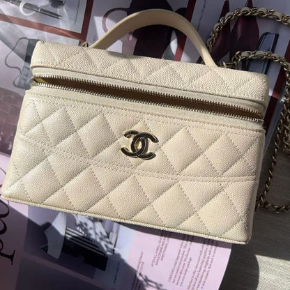 Beige quilted handbag with gold chain on a magazine