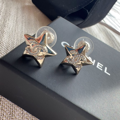 Star-shaped earrings on a Chanel box