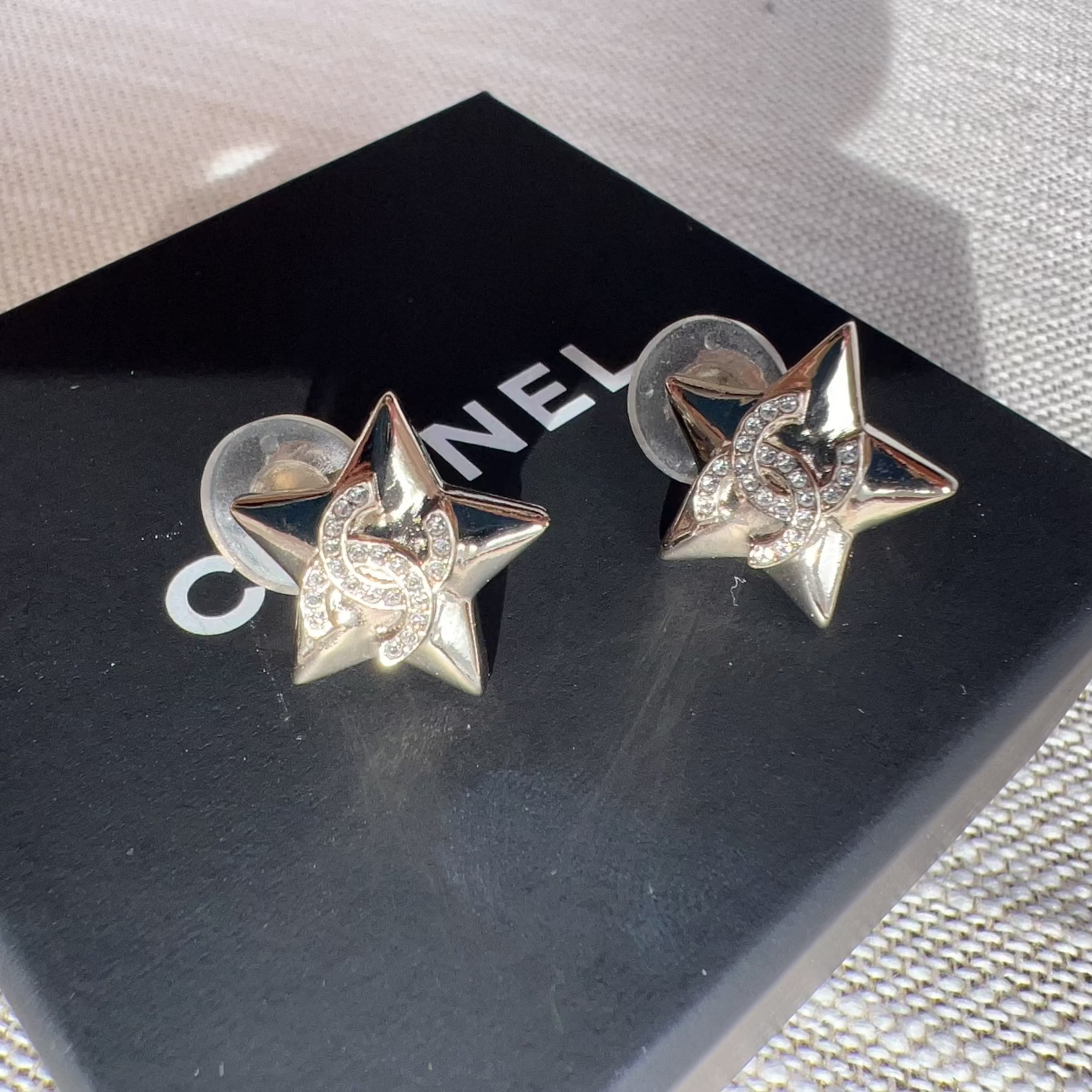 Star-shaped earrings on a black Chanel box