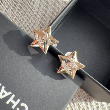 Star-shaped earrings on a black box with 'Chanel' branding.
