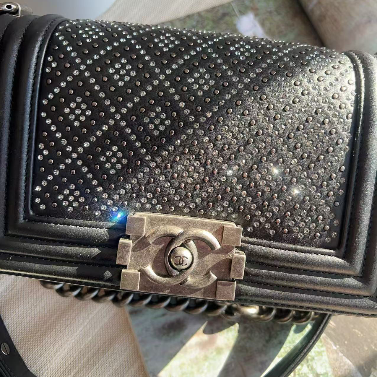 Black studded handbag with Chanel logo on a blurred background