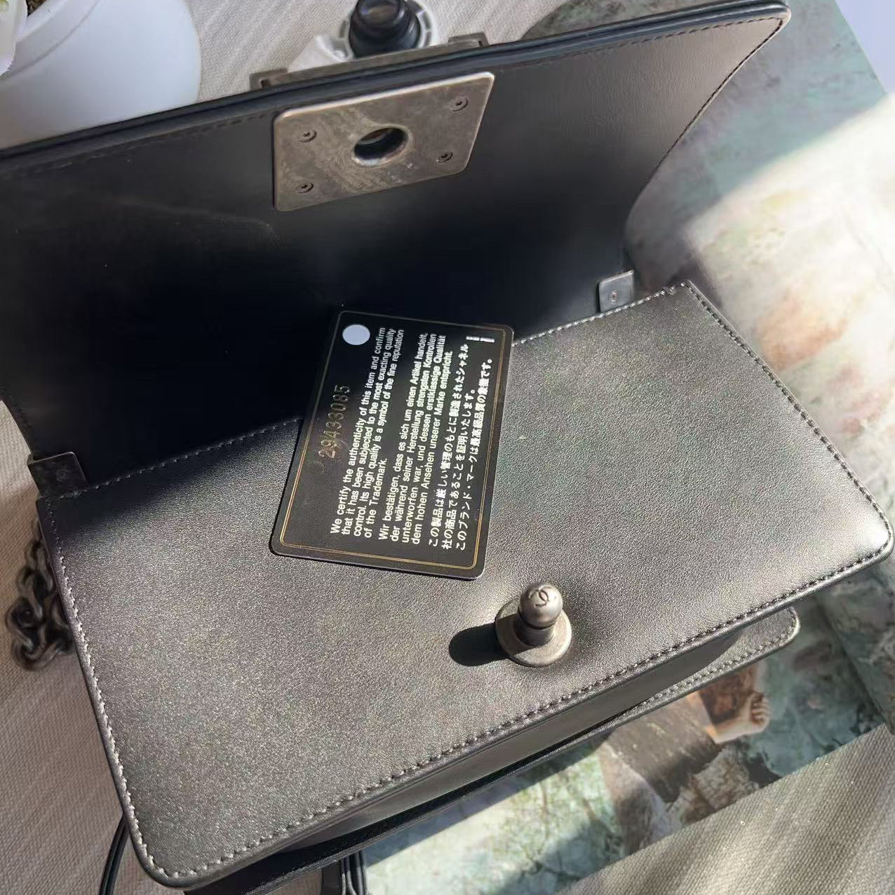 Gray handbag with a visible brand label on a blurred background