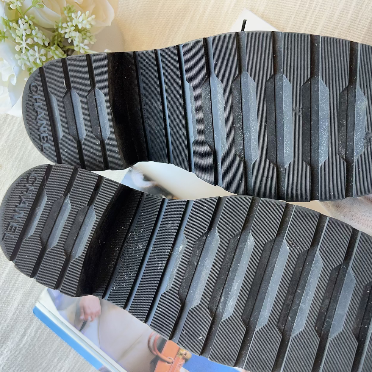 Close-up of Chanel flip-flops with textured sole on a light background