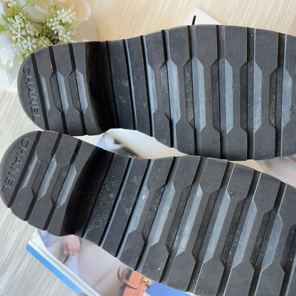 Close-up of Chanel flip-flops with textured sole on a light background